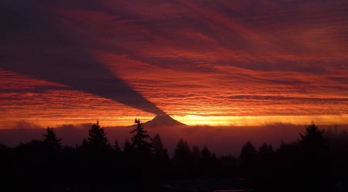 Гора, отбрасывающая тень на облака.