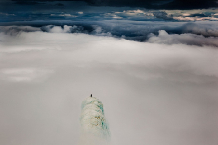 Альпинист стоит на вершине горы в Исландии.