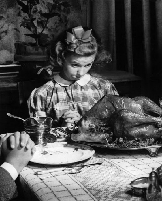 Пока родители произносят слова благодарности за праздничным столом, девочка жадно поедает газами индейку.