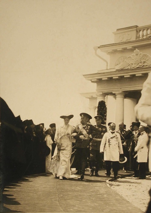  Император Николай II и императрица Александра Федоровна проходят мимо группы священнослужителей после окончания церемонии.