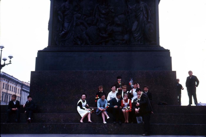 Молодежь отдыхающая на ступеньках памятника.
