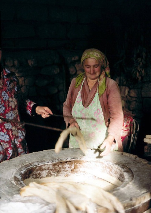 Грузинская женщина за выпечкой хлеба.
