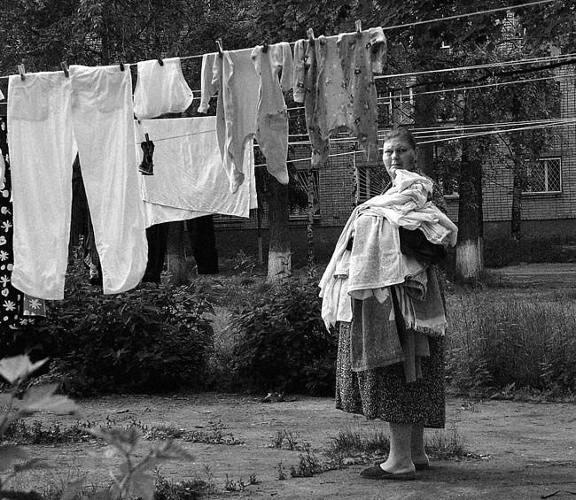 Женщина, развешивает выстиранное бельё в одном из дворов. СССР, 1970-е годы. 