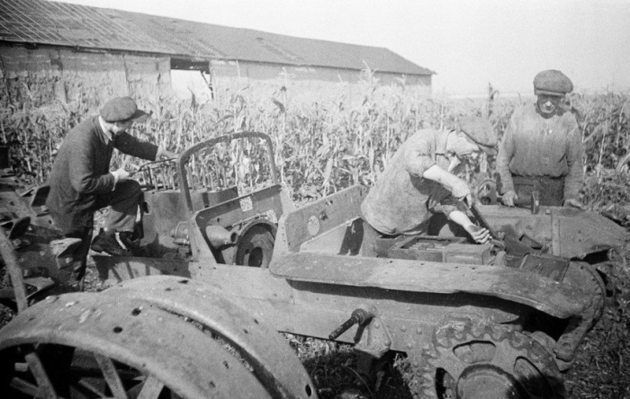 Мужчины ремонтируют трактор перед началом утренних работ. УССР, 1950-е годы.