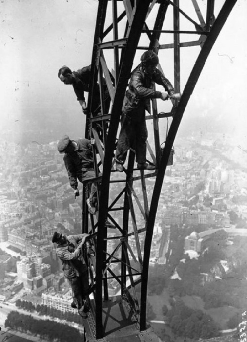 Рабочие окрашивают одну из опор Эйфелевой башни в 1932 году.