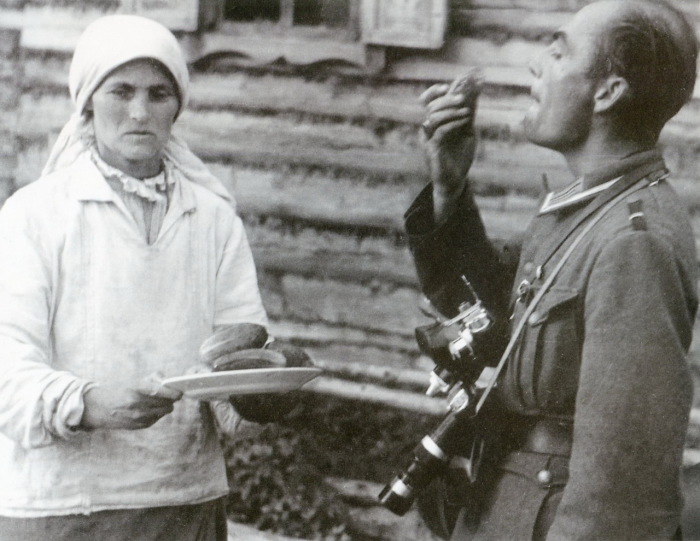  Немецкий репортер ест огурец, предложенный крестьянкой. Белоруссия, 1941 год. 