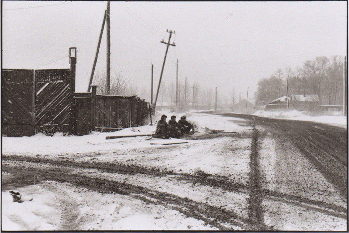 Мужчины, сидящие у дороги в снежную погоду. СССР, Иркутск, 1972 год.