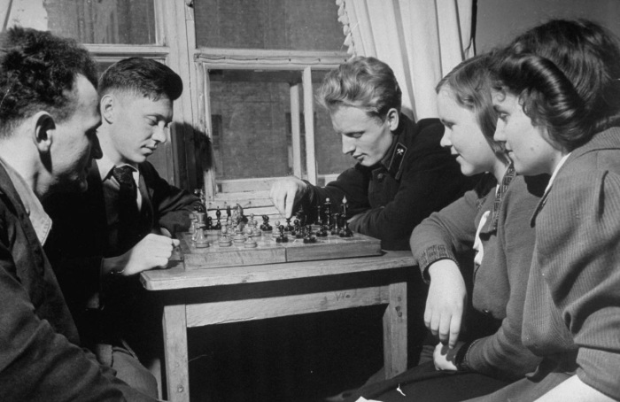Студенты, играющие в шахматы в общежитии в свободное время. 