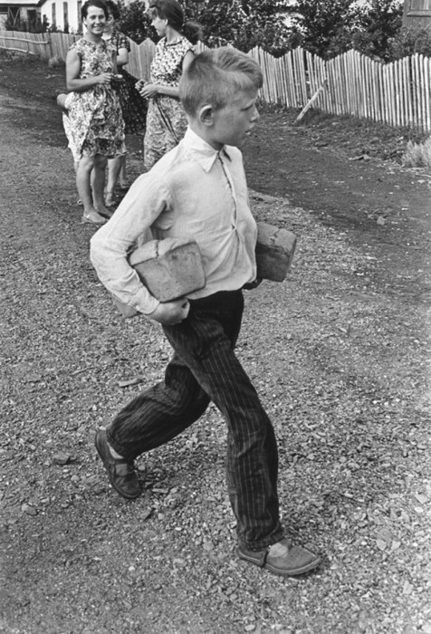 Мальчик несет домой две буханки хлеба. СССР, 1960 год. 