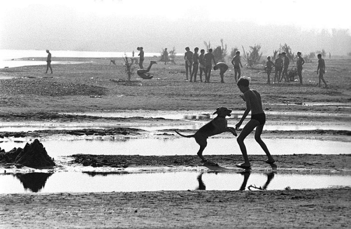 Подросток играется с собакой на пляже. СССР, Башкирия, 1978 год. 