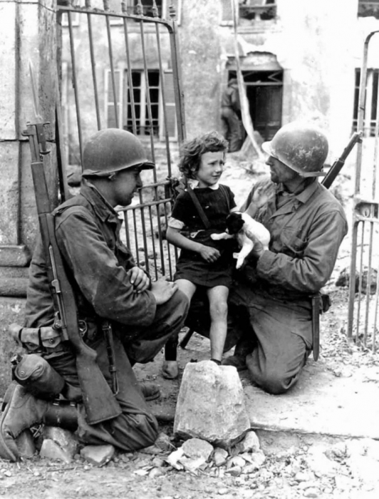Два американских солдата утешают плачущую девочку, 1944 год.