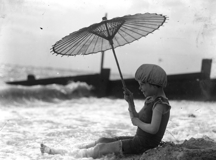 Ребёнок с зонтиком на пляже в 1920 году.