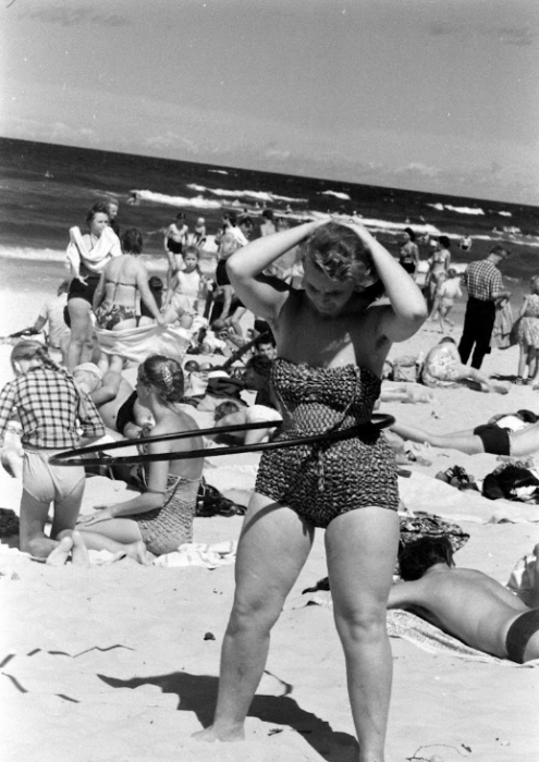 Девушка крутит обруч на пляже в Риге. 