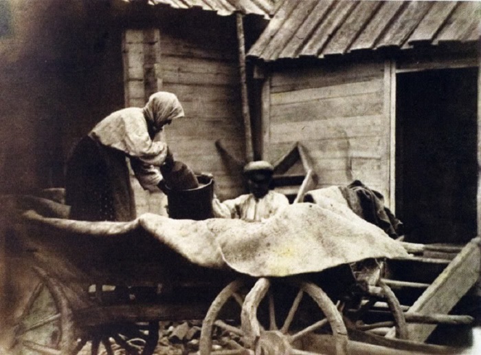 Казачка 72-двух лет ссыпает овёс. 1875-1876 год. Фото: Ivan Boldyrev. 