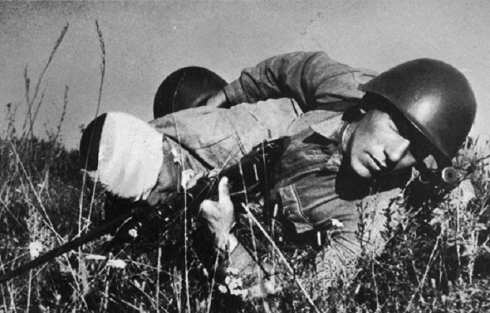 Красноармеец вытаскивает раненого товарища с поля боя на подступах к Сталинграду.