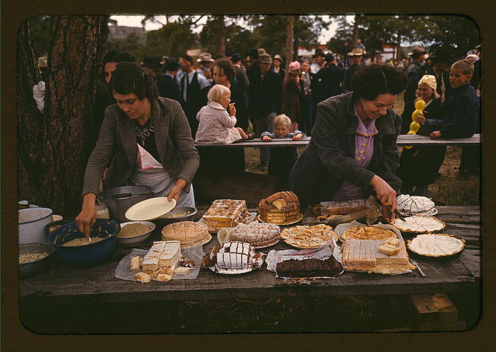 Две женщины режущие пироги и торты на пикнике во время ярмарки. США, Нью-Мексико, октябрь 1940 года. Автор: Russell Lee.
