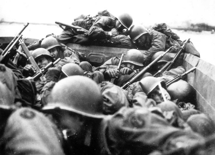 Американские солдаты на десантной лодке форсируют Рейн под огнем немецких солдат.