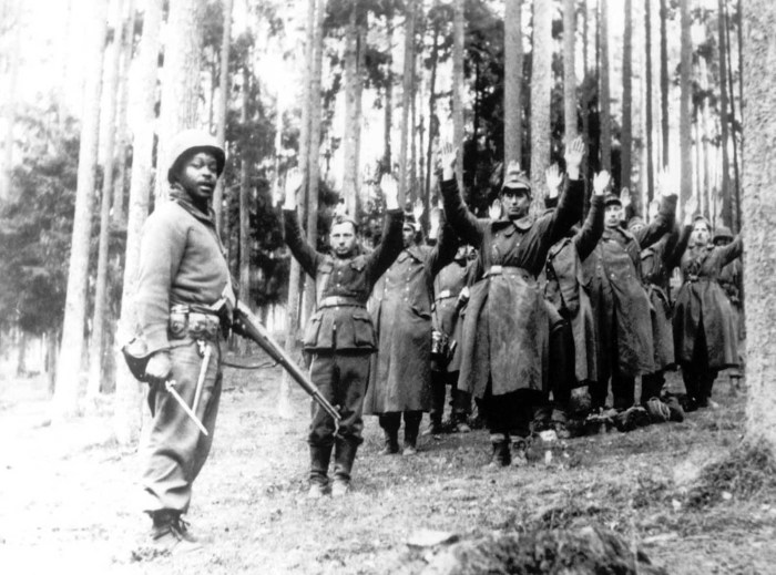 Американский солдат из 12-й бронетанковой дивизии рядом с группой пленных солдат. 