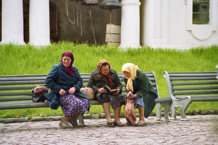 Пожилые женщины читают книгу в парке. 