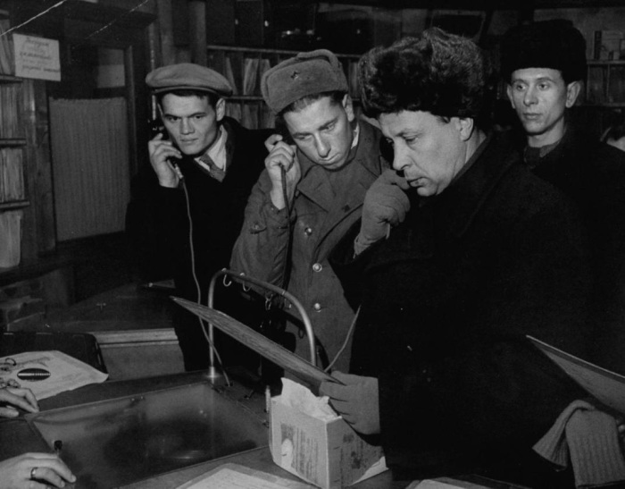Люди, прослушивающие новые песни в местном магазине. СССР, Москва, 1955 год.