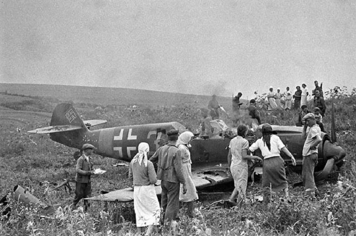 Колхозники рассматривают сбитый немецкий самолет в 1944 году. 
