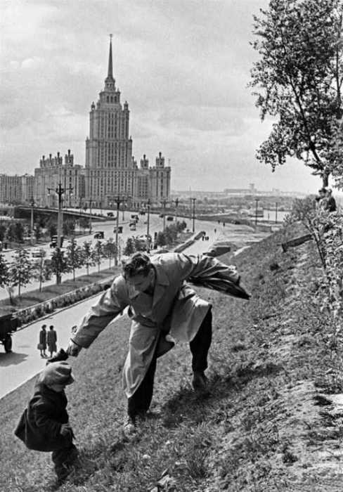 Отец помогает своему сыну подняться на вершину холма. СССР, Москва, 1972 год.