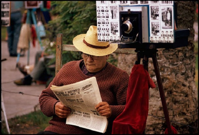 Уличный фотограф читает ежедневную газету «Комерсио».
