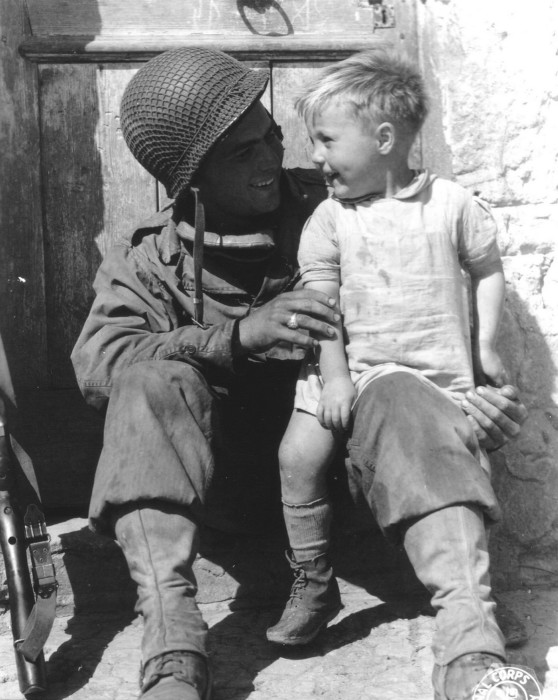 Американский солдат держит на руках ребёнка в коммуне Тревьер.