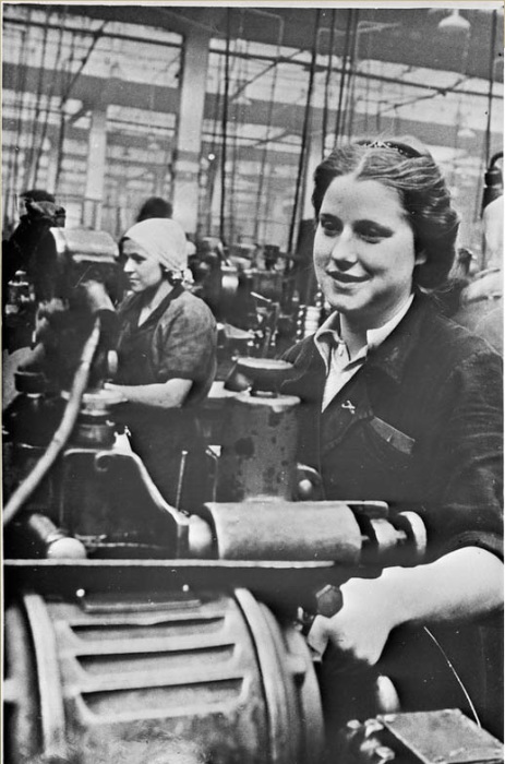 Женщина, работающая на токарном станке на фабрике. СССР, 1940 год. 