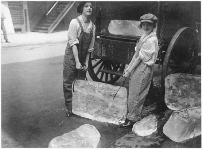 Девушки занимаются погрузкой тяжёлых блоков льда во время войны.