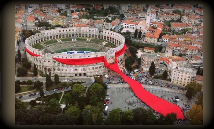 Гигантский красный галстук вокруг римской арены в Пуле. Хорватия. 