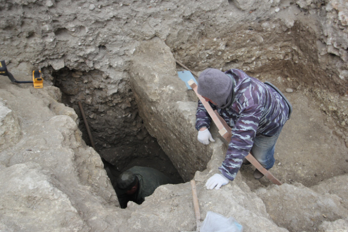Археолог расчищает захоронение. /Фото: archaeolog.ru