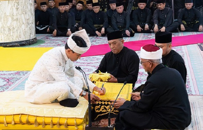 Кадр со свадьбы. Жених ставит свою подпись. /Фото: Департамент информации Брунея