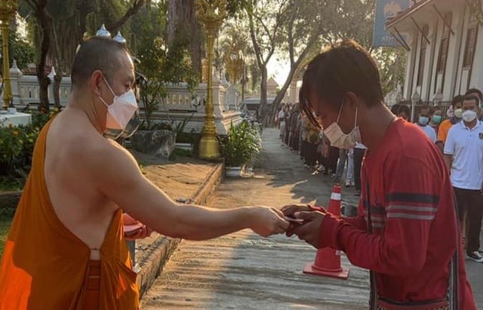 Монах раздает деньги нуждающимся. 